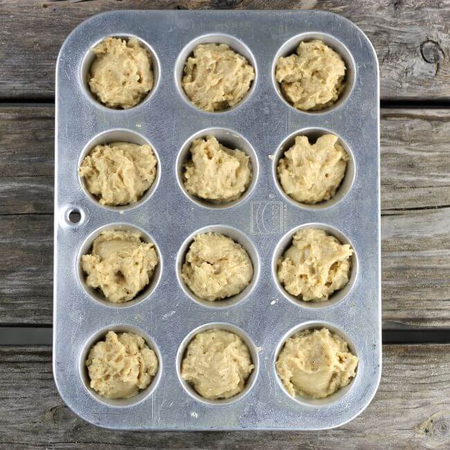 Muffin batter in a in mini muffin tins.
