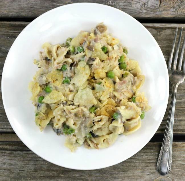 Overhead view of tuna noodle casserole on a white plate with a fork on the side.