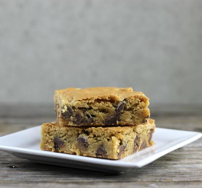 Two chocolate chip bars on a white plate.