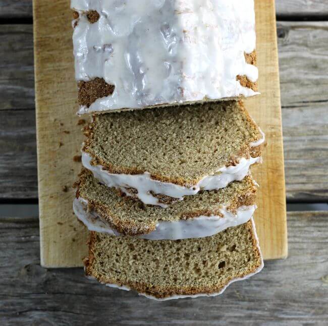 Bread that is sliced sitting on a breadboard.