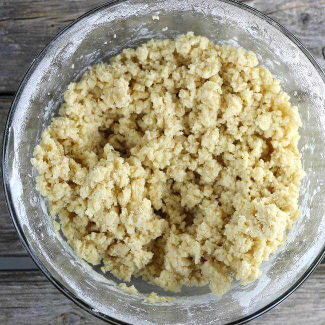 Crumbly dough in a glass bowl.