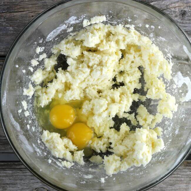 Eggs added to the batter in a glass bowl.