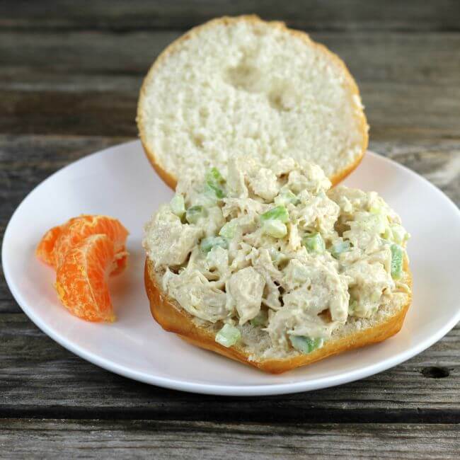 Side view of a chicken sandwich with the top of the roll on the side.