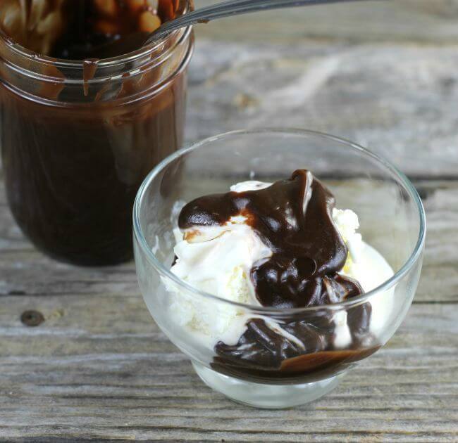 A bowl of ice cream with chocolate sauce on top of the ice cream.