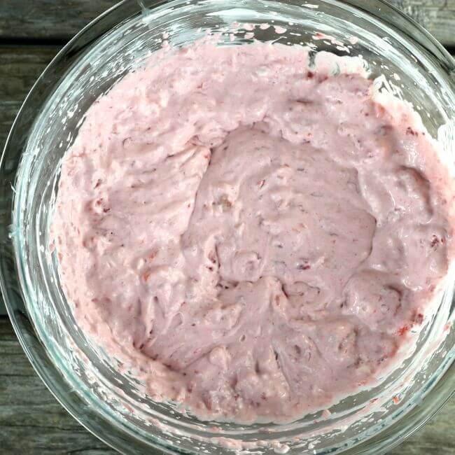 Strawberries and cream cheese whipped together in a bowl.