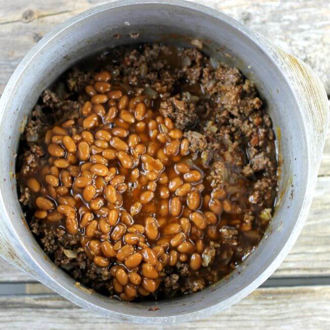 Beans are added to the hamburger in the Dutch oven.