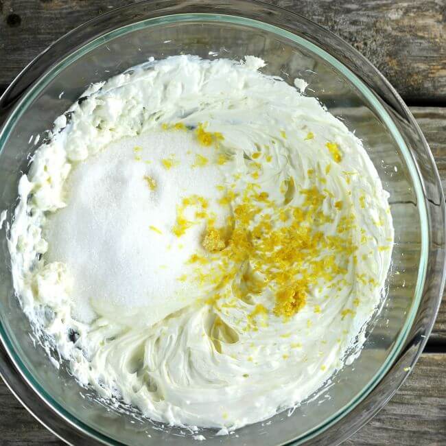 Sugar and lemon zest is added to the cream cheese and sour cream mixture.