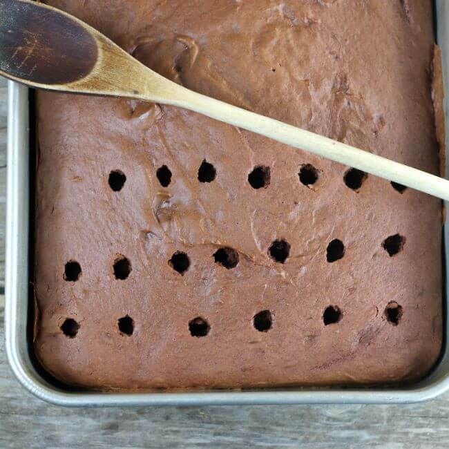 A baked cake with holes poked in it.