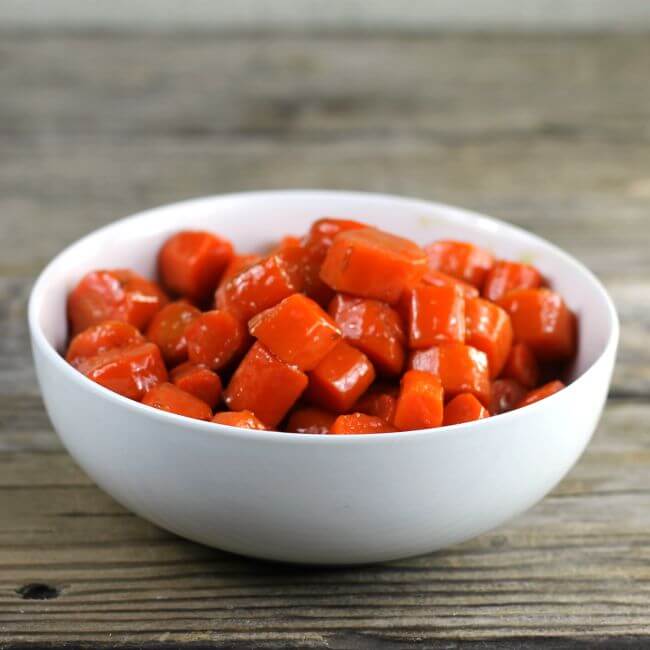 A side view of a bowl of brown sugar glazed carrots