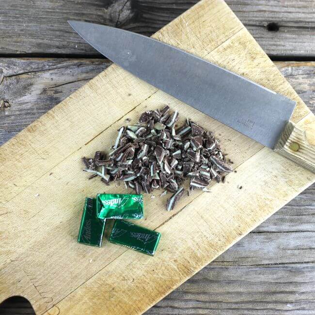 A cutting board with chopped Andes mint candies.