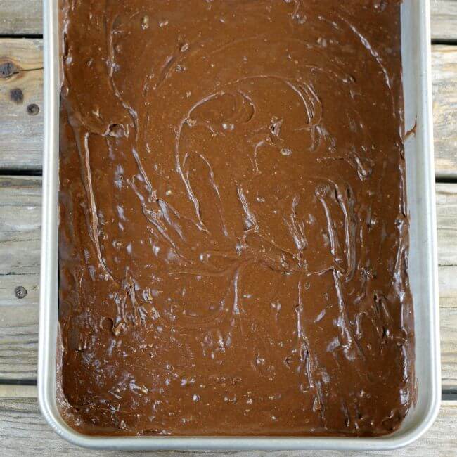 Brownie batter is spread in the prepared pan.