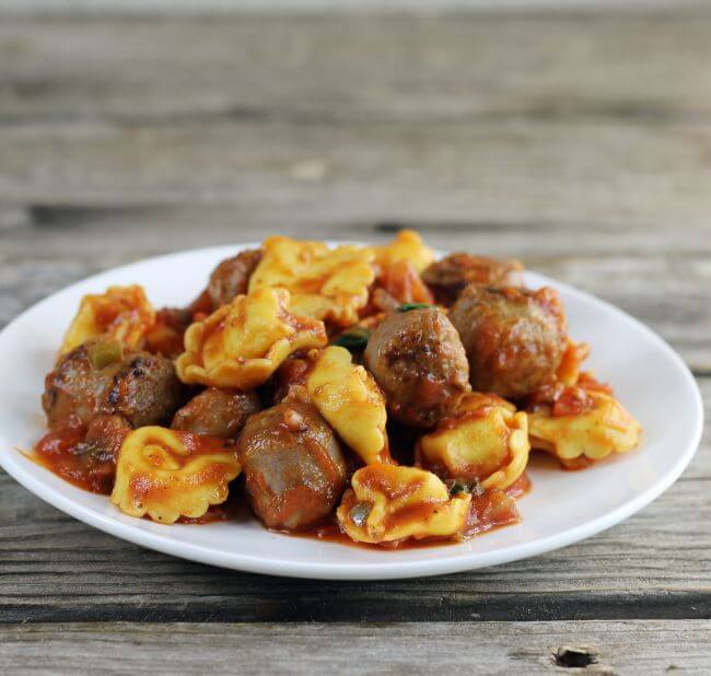 A side angle view of Italian sausage and tortellini.