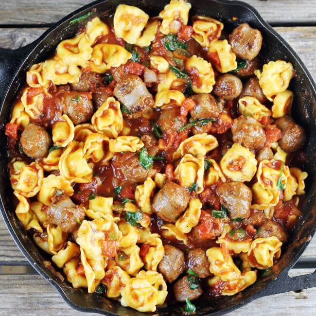 Cheese tortellini and Italian sauce in a skillet.