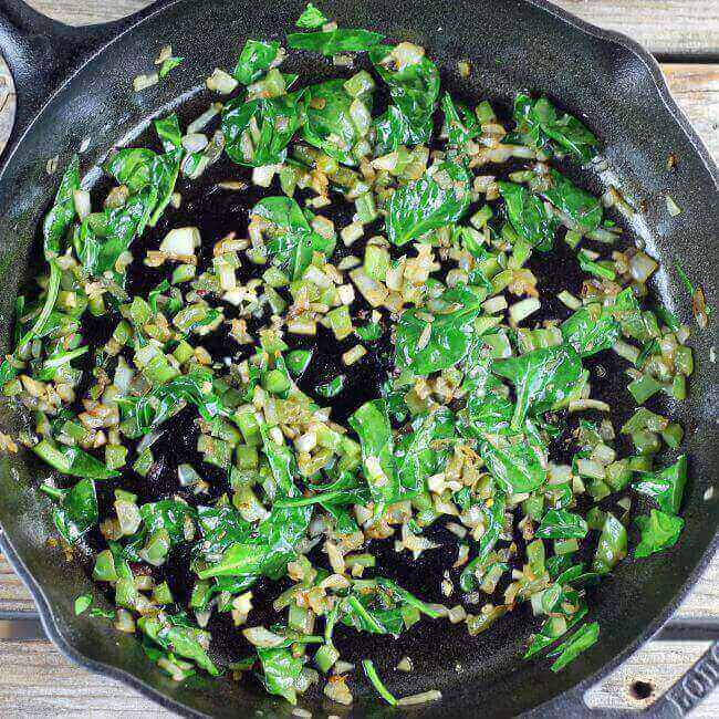 Spinach is added to the skillet.