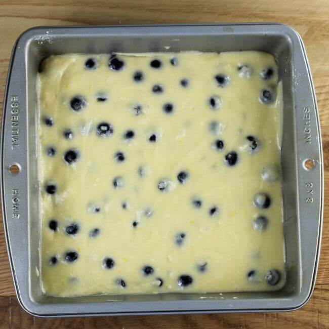 The lemon blueberry batter is spread in the baking pan.