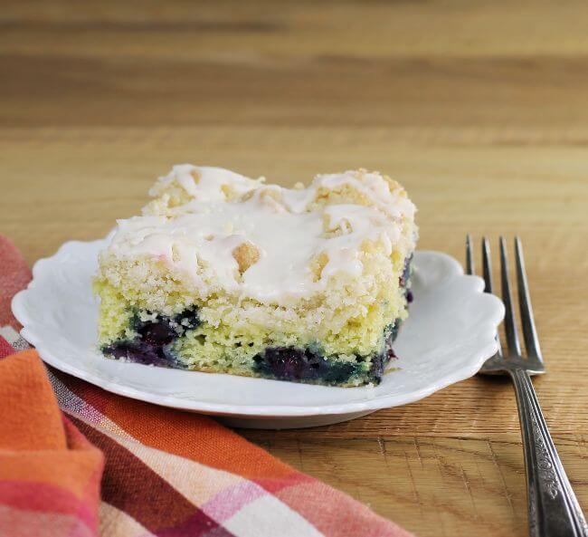 Side angle view of coffee cake on a plate with a fork on the side.