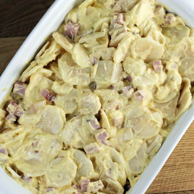 White sauce is added to the potatoes and ham.