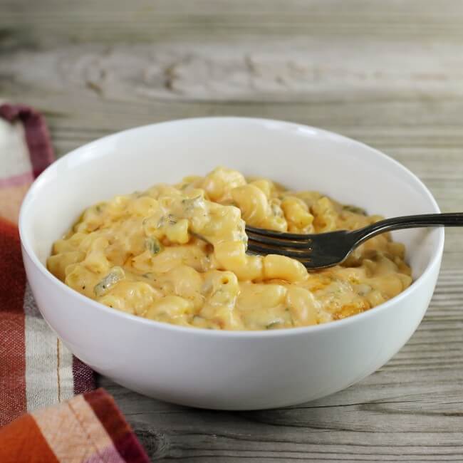 A sige angle view of a bowl with mac and cheese and a fork.