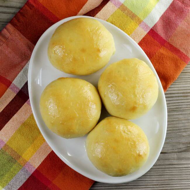 Looking down at a platter of honey glazed dinner rolls.