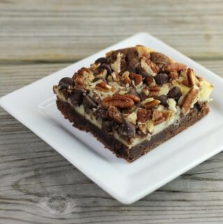 Side angle view of a cream cheese brownie on a white plate.
