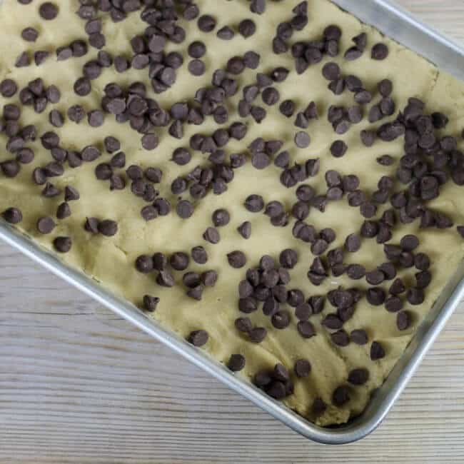 Chocolate chips are sprinkled over top of the dough.