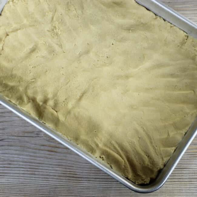 The dough is patted into a baking pan.