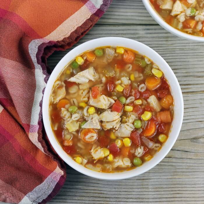 Looking down at a couple of bowls of soup with a napkin on the side.