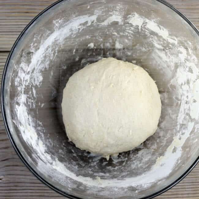 Dough is rolled into a ball in the bowl.