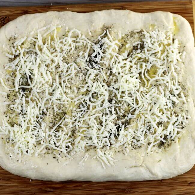 Mozzarella is added to the top of the pizza dough.