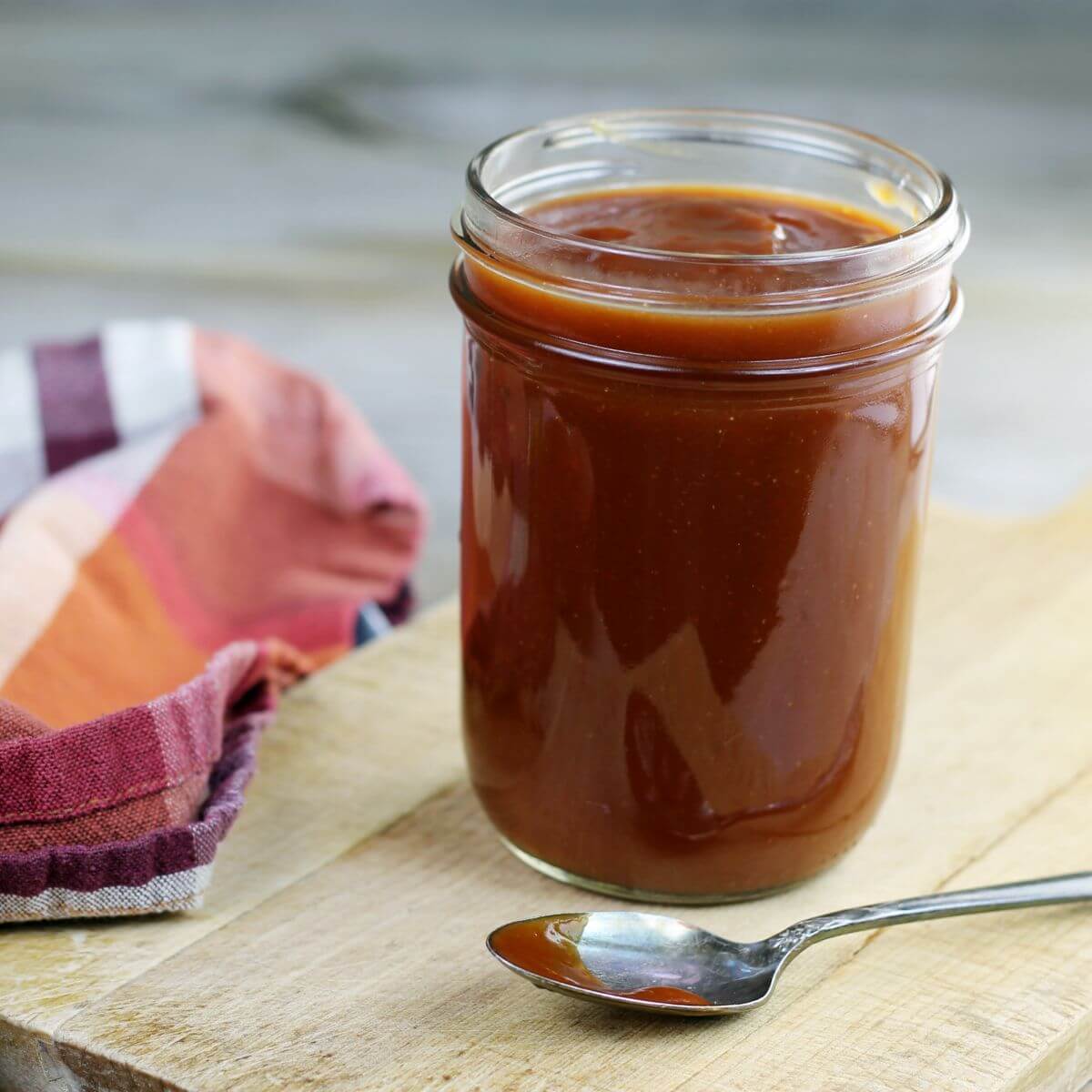 A side angle view of a jar of barbecue sauce. 