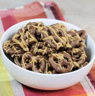 A bowl of pretzels covered with chocolate and peanut butter.