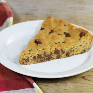 A side angle view of a slice of cookie on a white plate.
