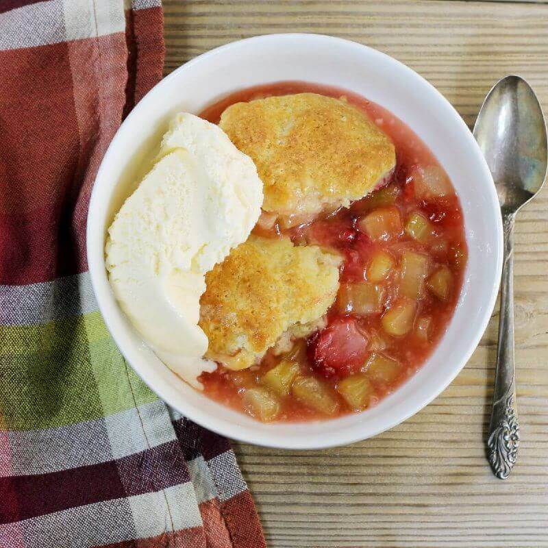 Looking down at a bowl of cobbler with a scoop of on top.