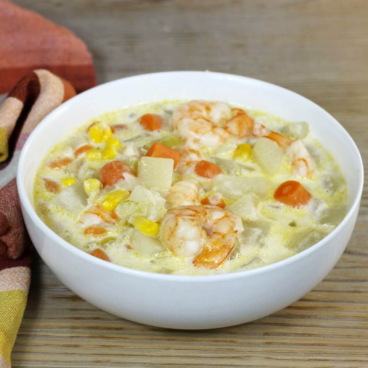 A side angle view of a bowl of shirmp soup.