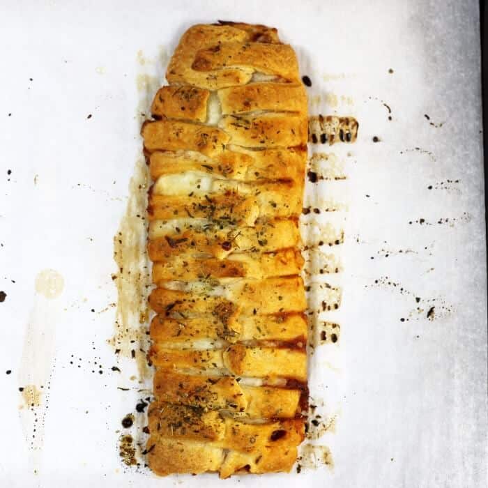 Looking down at a baked pizza braid on a parchment paper.