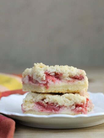 A stack of strawberry bars on a round white plate.