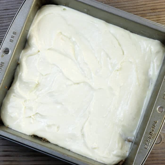 Cream cheese filling is spread over a crust.